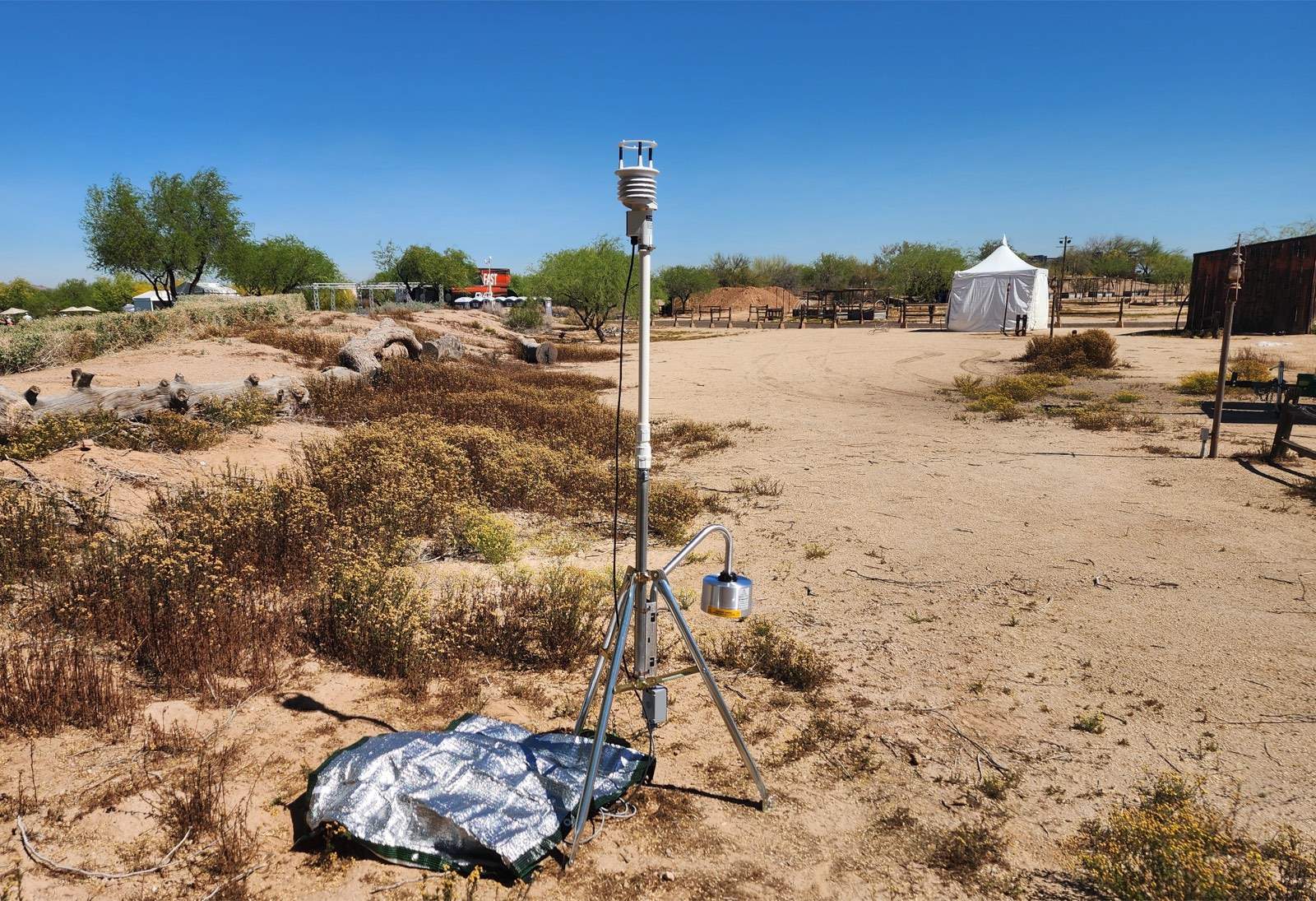 Measured portable weather station on a tripod at a professional sporting event, with a sonic wind sensor at the top and an electric field mill hanging below