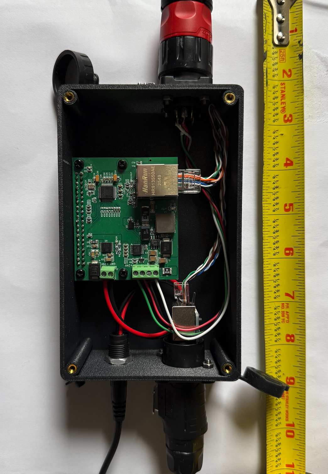 Custom PCB inside the 3D-printed enclosure with tape measure showing compact form factor
